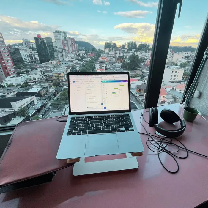 A laptop on a desk overlooking a city — where KDPChimp is run from